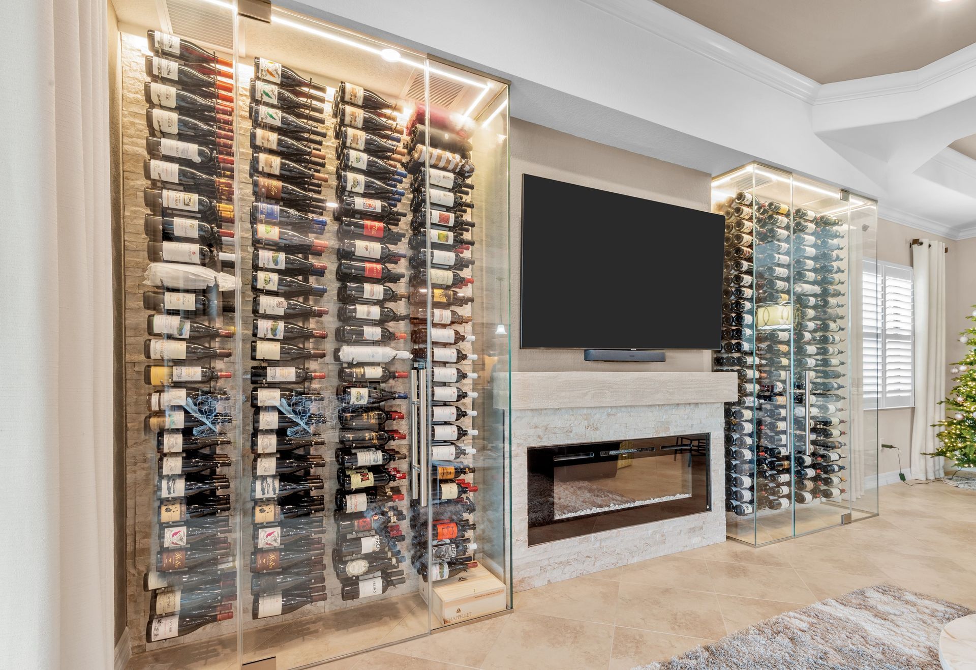 A living room with a wine cellar and a flat screen tv.
