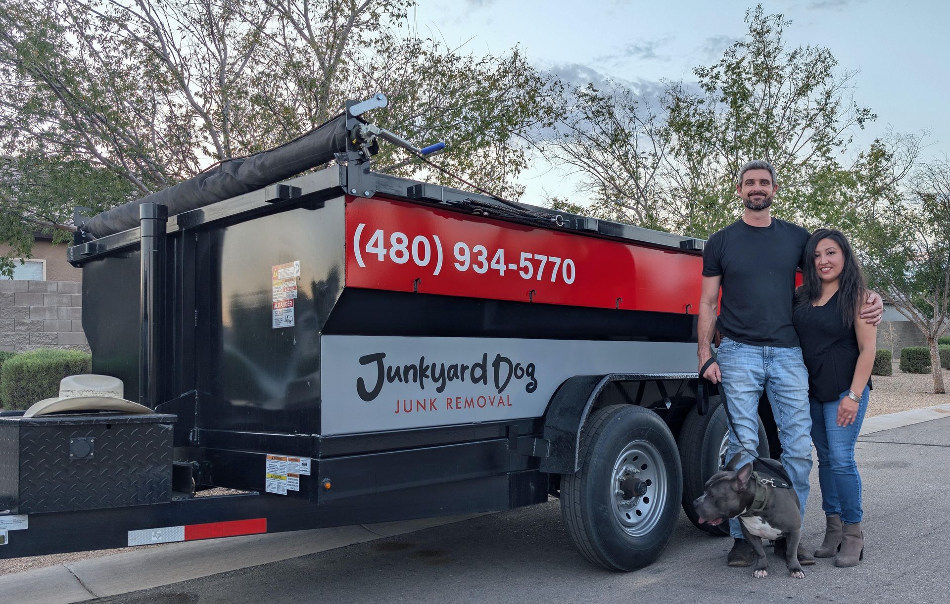 A man is standing in front of a pile of garbage.