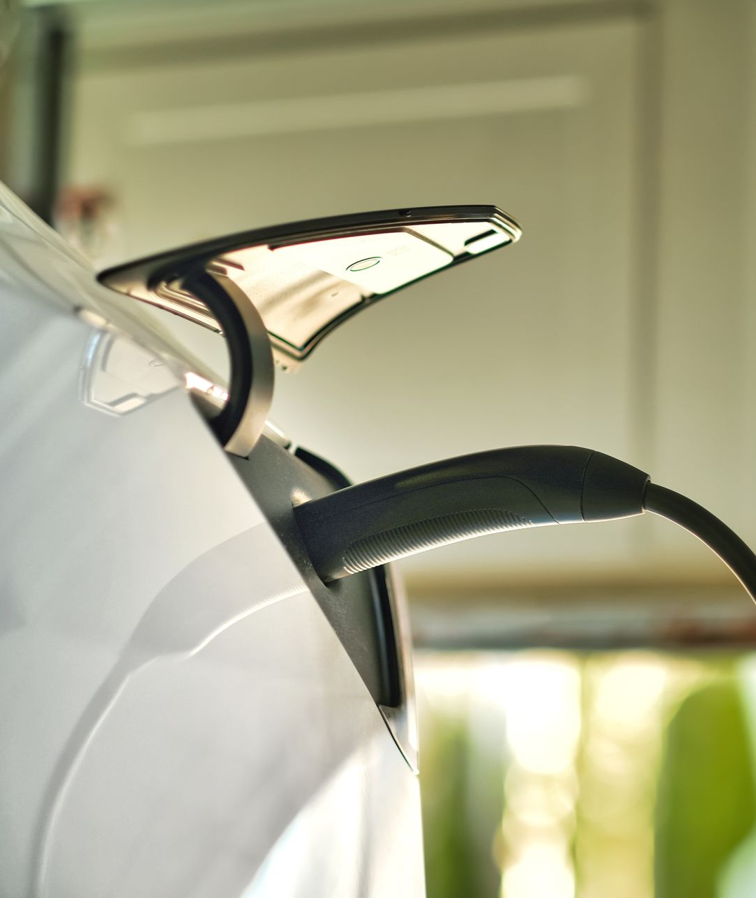 Close-up of a white electric kettle with a black handle and chrome spout on a countertop
