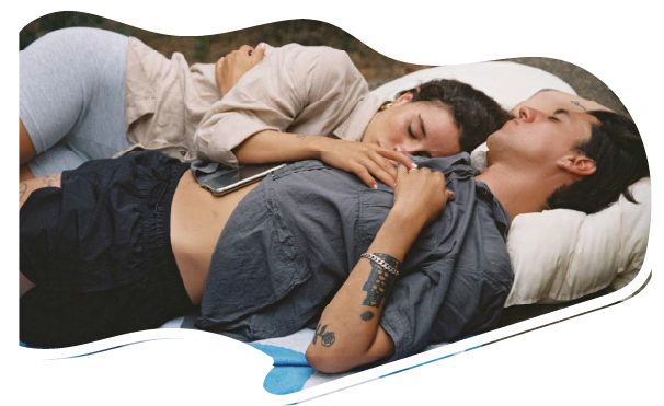 A man and a woman are laying on a blanket together