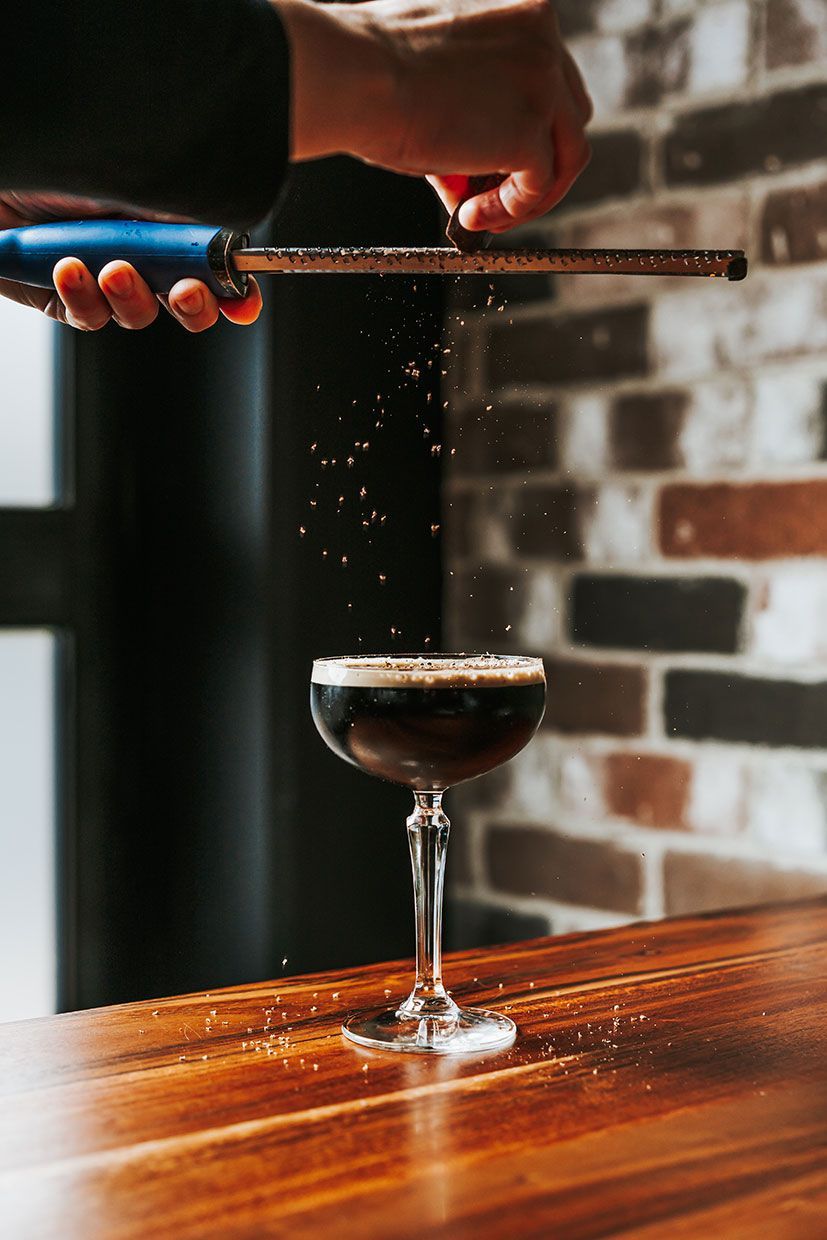 A Person is Grating Sugar Over a Drink in a Glass on a Wooden Table — Fedeles East Gosford in East Gosford, NSW