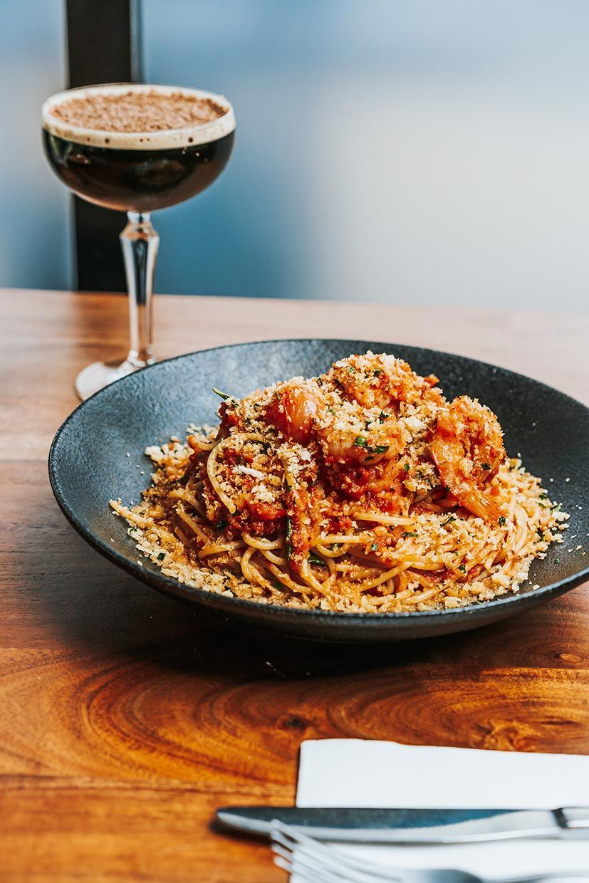 A Plate of Spaghetti and a Glass of Wine on a Wooden Table — Fedeles East Gosford in East Gosford, NSW