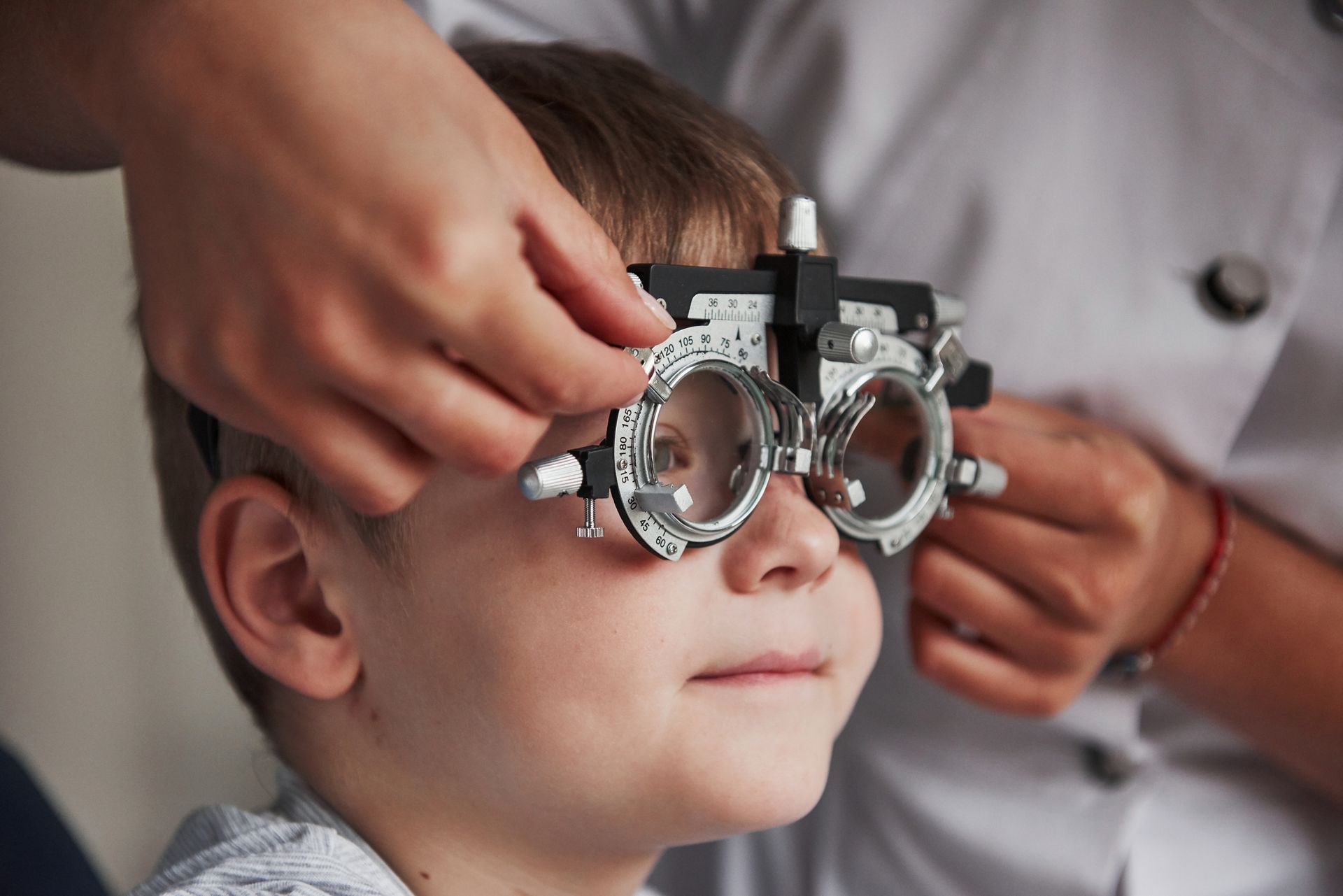 A young boy is getting his eyes checked by an ophthalmologist.