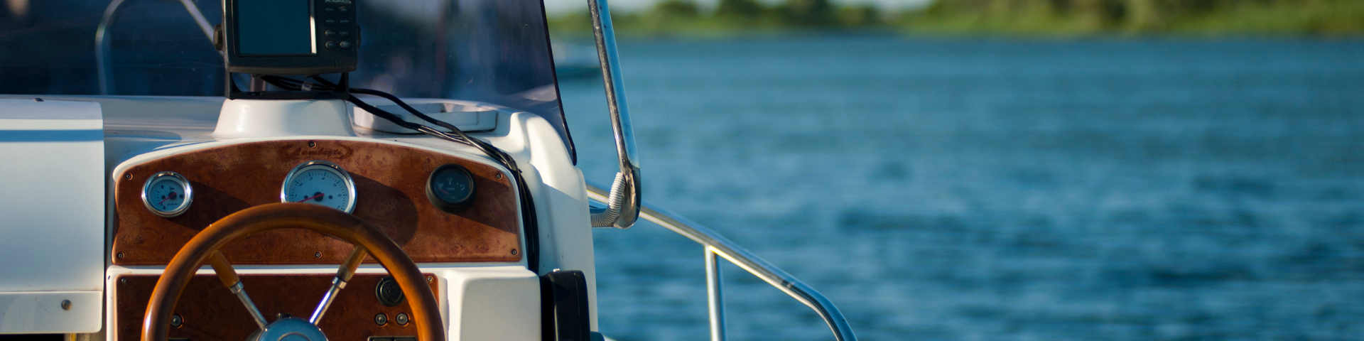 Cockpit view from a sailboat on blue water with a sail and rope in the foreground