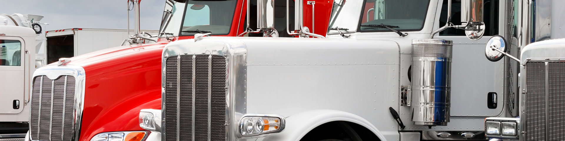 Lineup of semi trucks with red and white cabs parked side by side