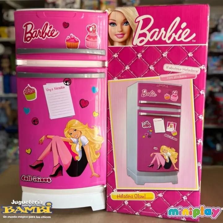 Caja de juego de cocina de juguete rosa con temática de Barbie, con horno, nevera y accesorios mostrados en el empaque.