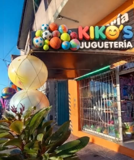 Fachada colorida de la juguetería Kiko's con decoraciones de globos y escaparate.