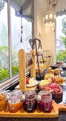 Uma mesa de bufê com potes de geléia e pão.