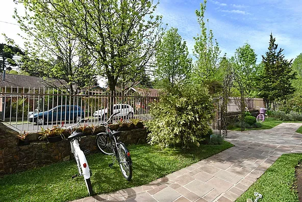 Duas bicicletas estão estacionadas na calçada de um parque.
