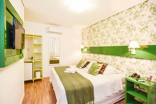 Um quarto de hotel com cama king size e TV de tela plana.