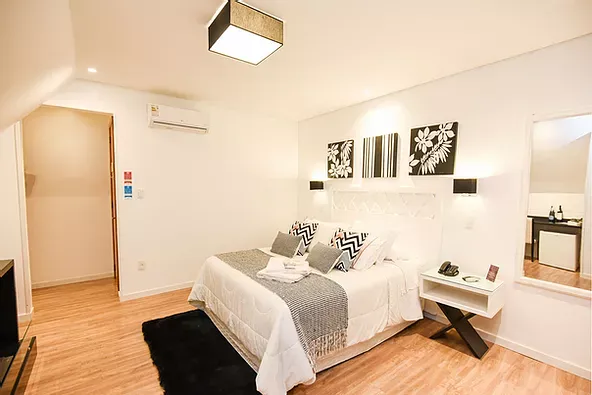 Há uma cama grande no meio do quarto.
