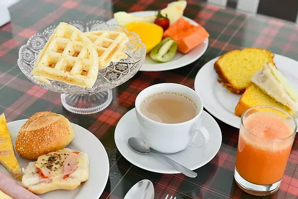 Uma mesa com pratos de comida e uma xícara de café.
