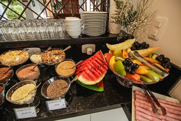 Uma mesa de buffet com uma variedade de alimentos, incluindo melancia e frutas.