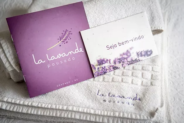 Um livro roxo e uma toalha branca estão sobre a cama.