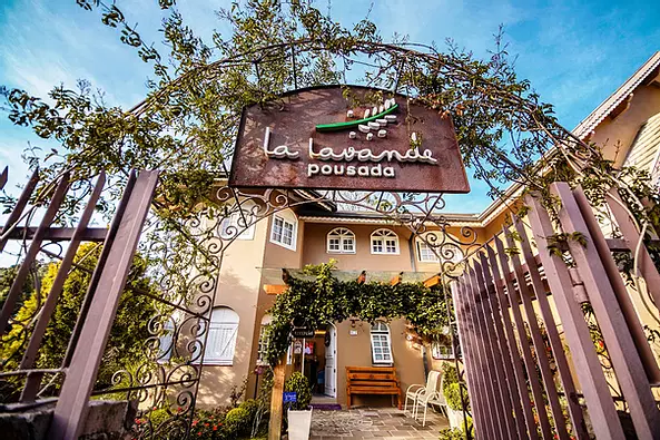 A entrada de uma casa com uma placa acima do portão.