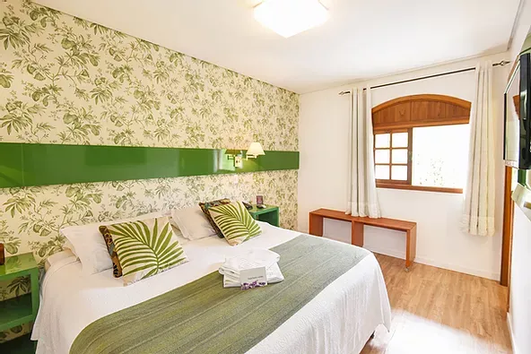 Um quarto de hotel com uma cama grande e uma janela