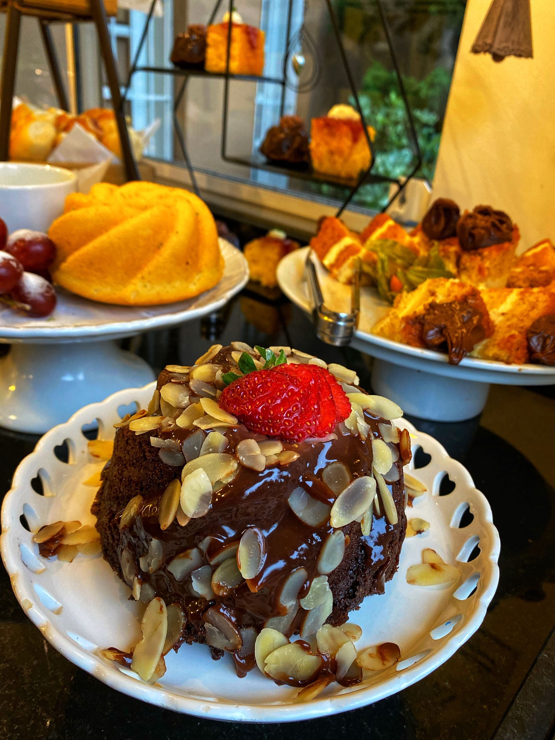 Um bolo de chocolate com amêndoas e um morango por cima