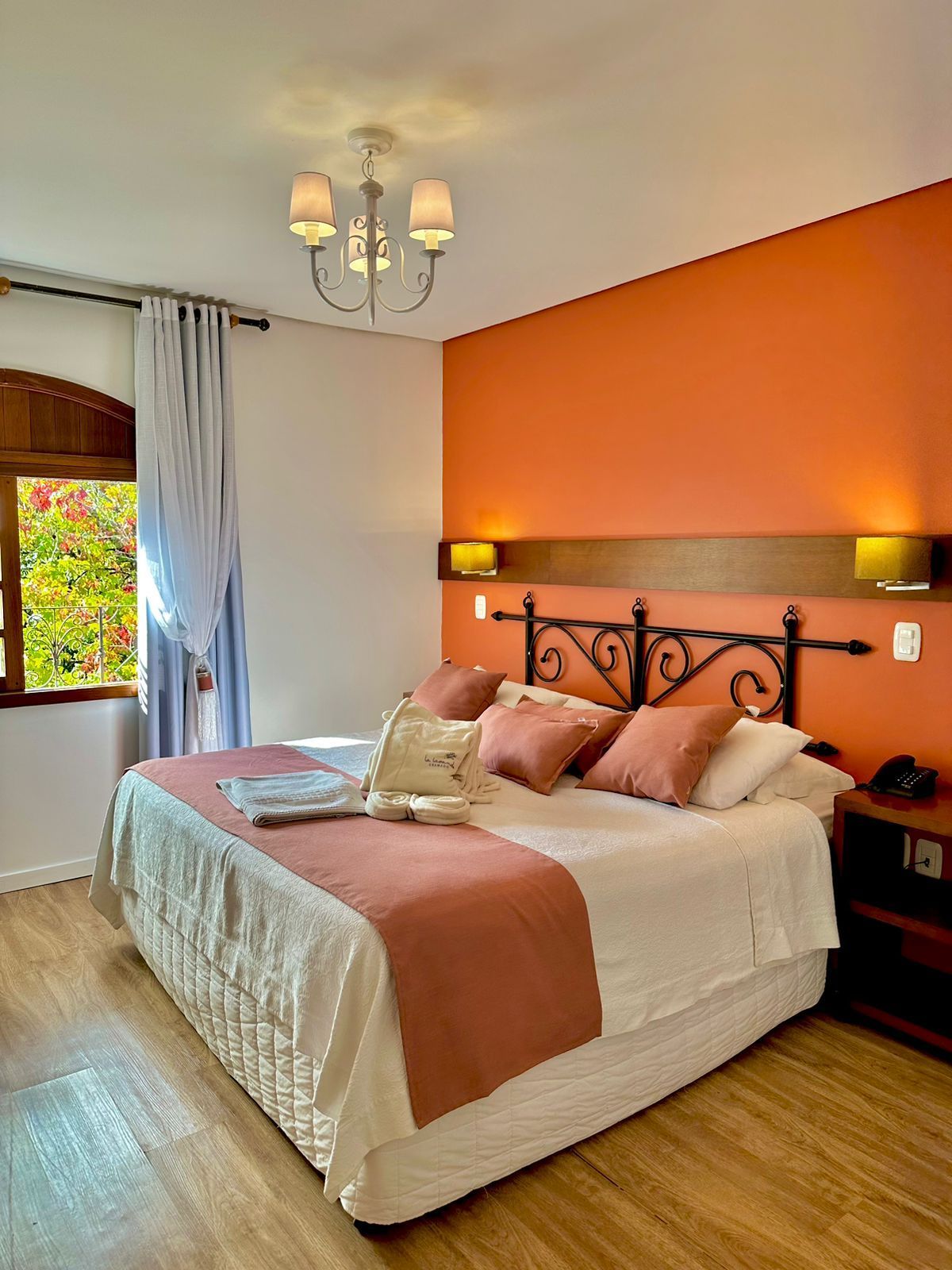 Um quarto com cama king size e paredes laranja.