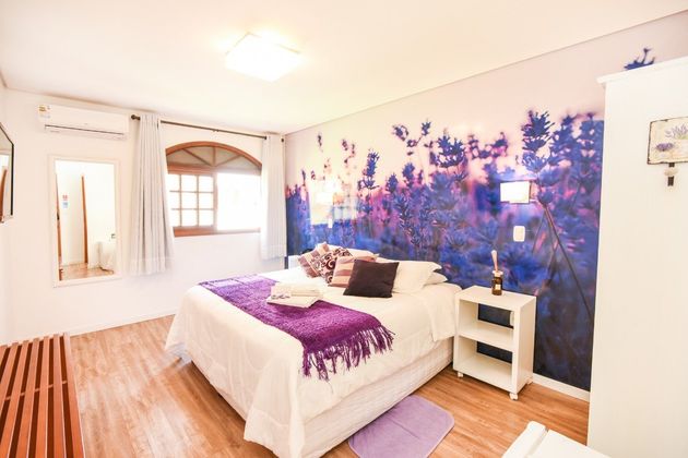 Um quarto com uma cama grande e um mural roxo.