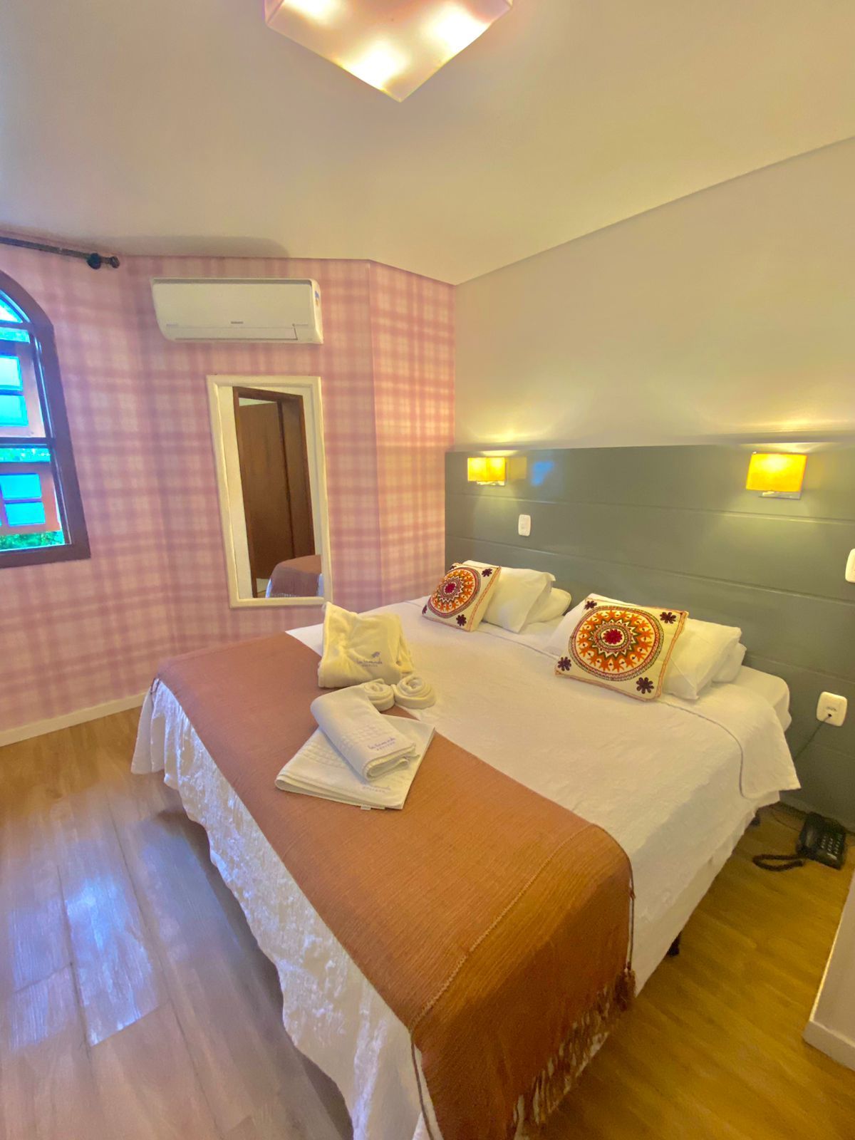 Há uma cama grande no meio do quarto.