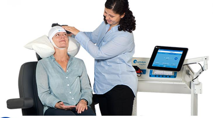 A woman is sitting in a chair with a bandage on her head.