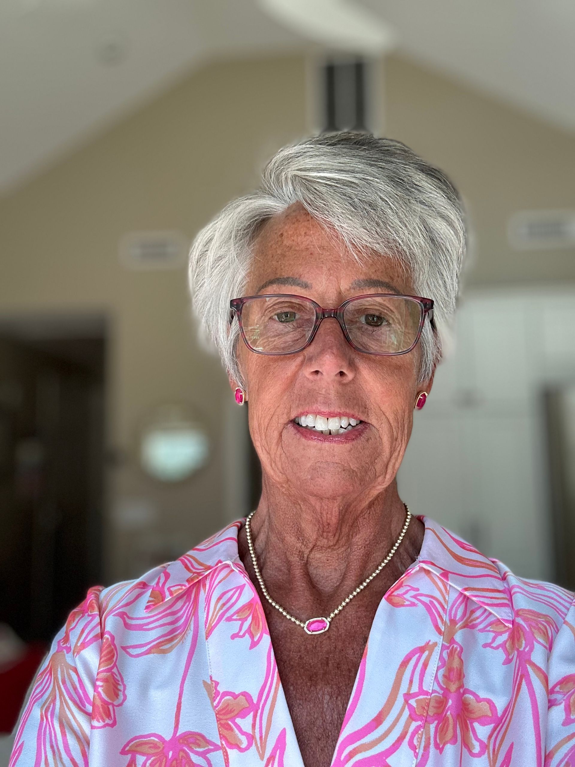 Jodi F. Conway, LADC, MAC, CSAT-s, CCPS-c Co-Founder, New England Recovery Associates | Serving Danvers, Greater Boston, NE Massachusetts, New Hampshire, Southern Maine A person with short, silver hair and glasses wears a pink and white floral top and a necklace against a blurred background.