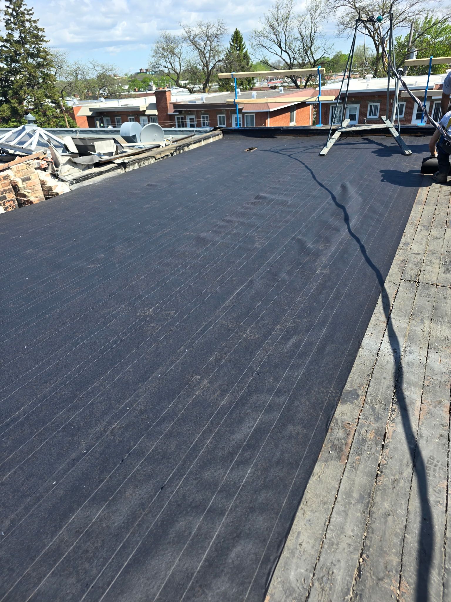 Membrane d'étanchéité noire installée sur un toit plat en construction.