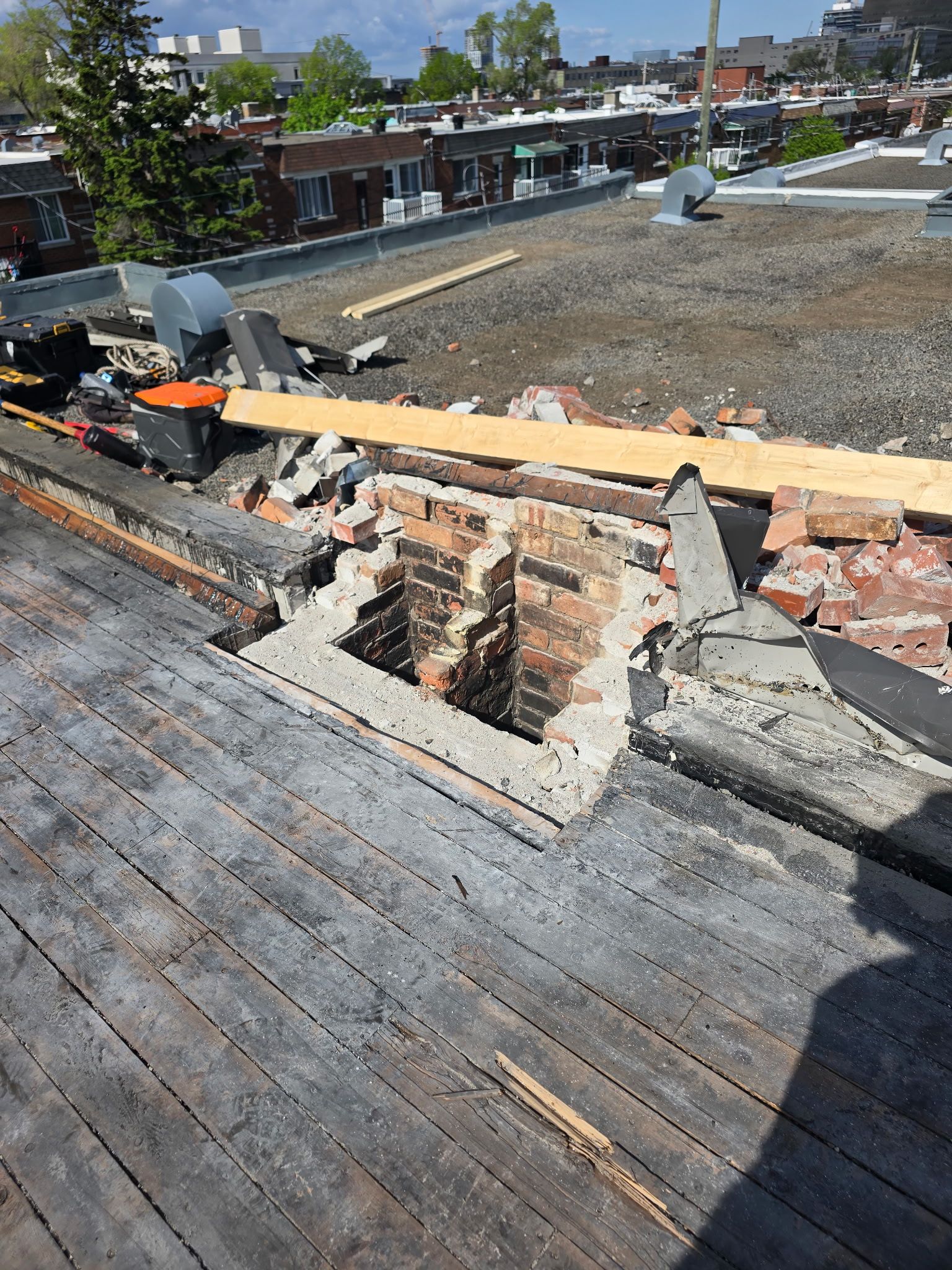 Toiture avec une grande ouverture structurelle en briques et en bois en cours de réparation par une journée ensoleillée