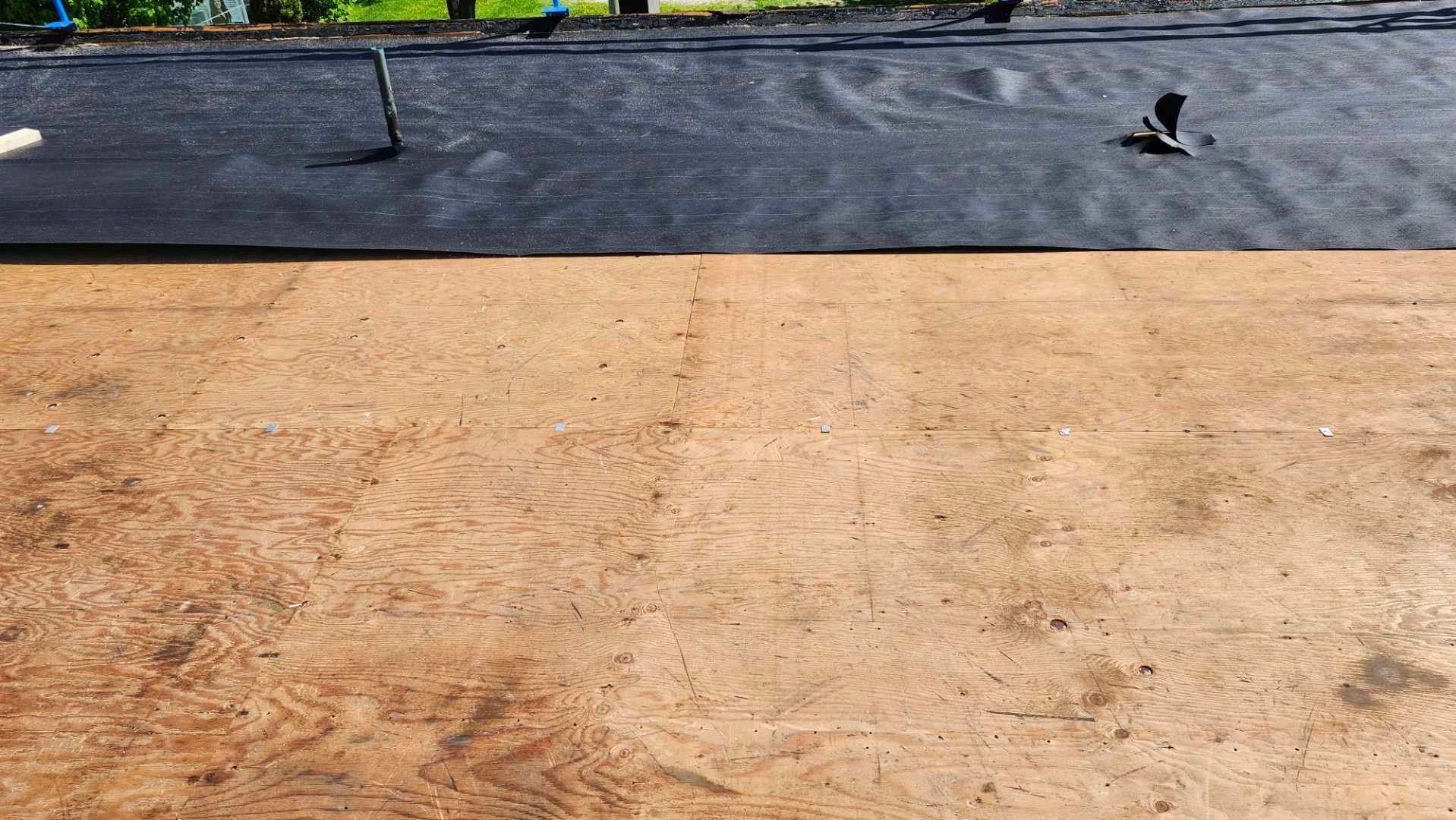 Toiture nue avec membrane d'étanchéité noire sur surface en béton beige