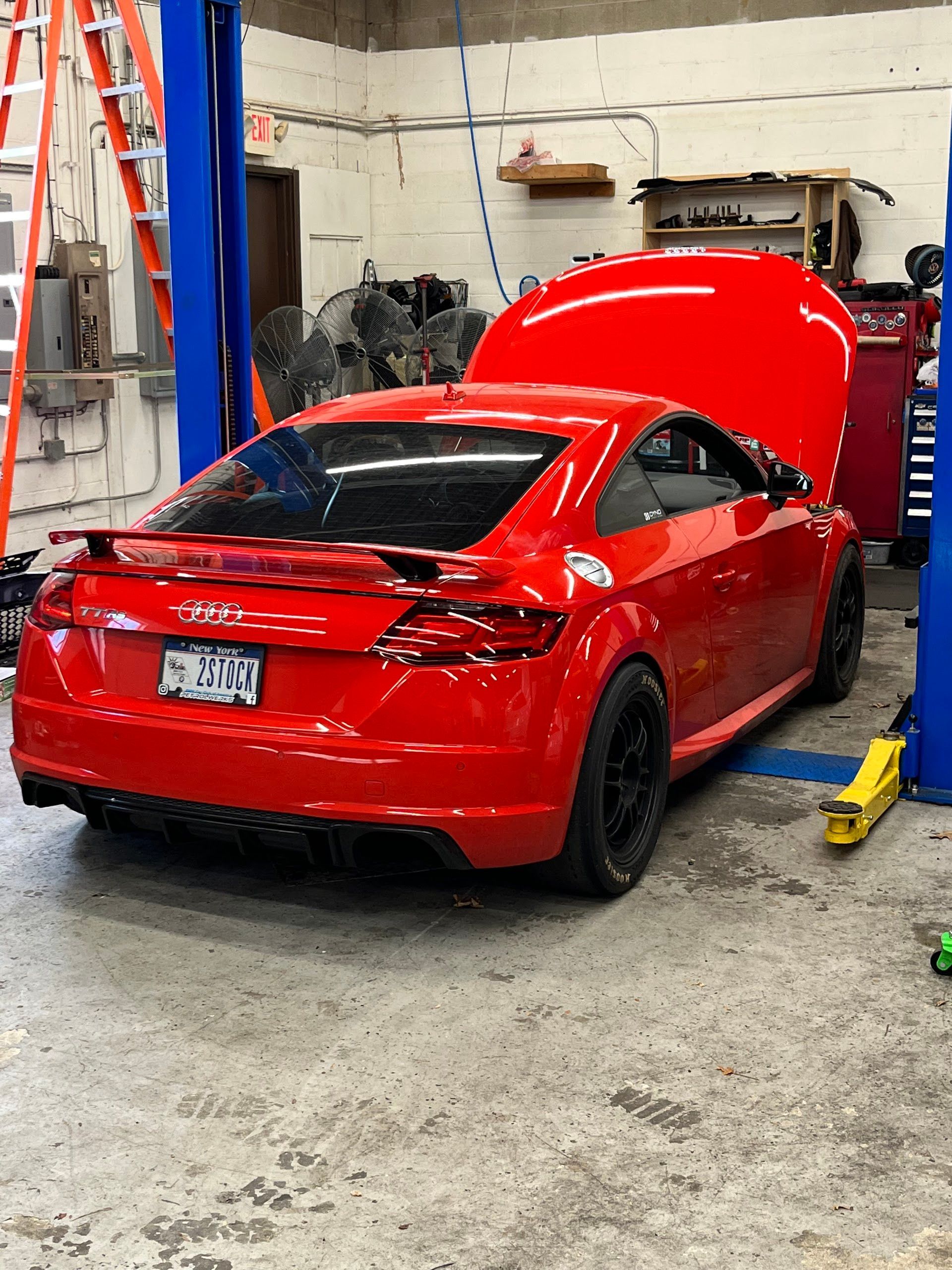 Red Audi TT coupe in a repair shop with hood open.| A2B Euro Car Repair