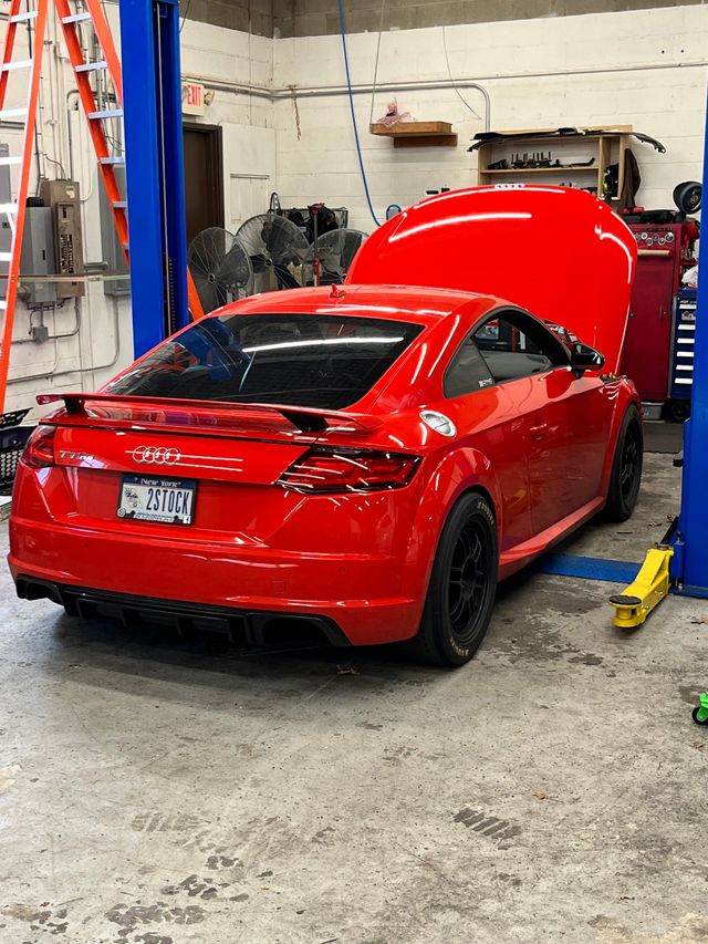 Red Audi TT coupe in a repair shop with hood open.| A2B Euro Car Repair