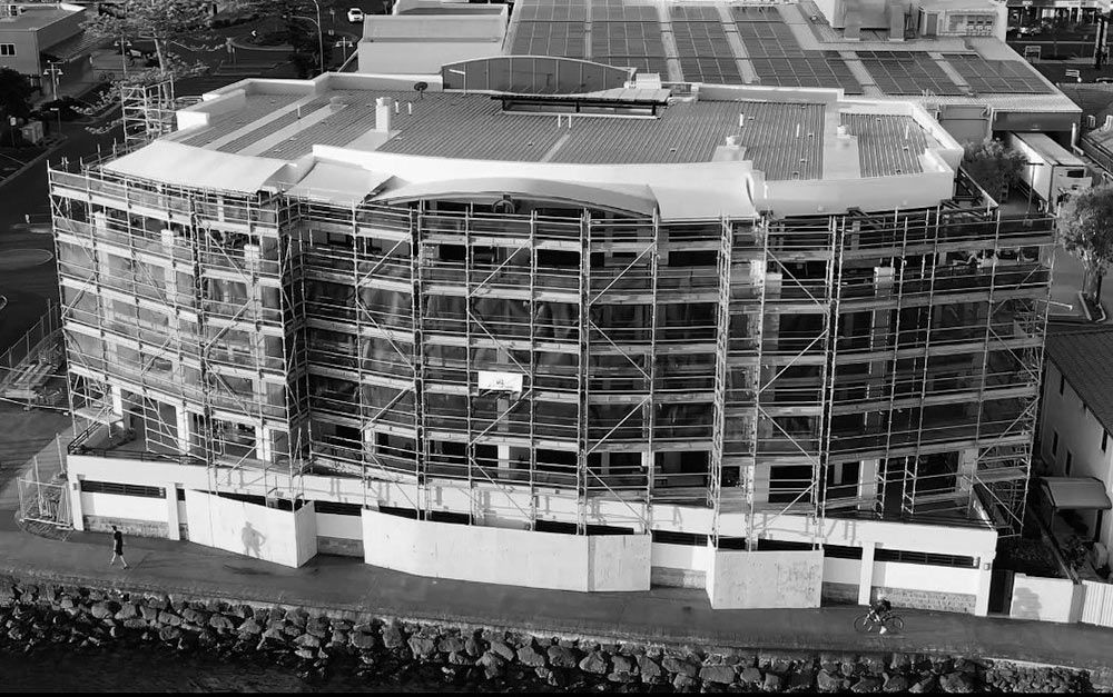 An Aerial View of a Building Under Construction With Scaffolding Around It — RM Scaffolding Solutions in Murwillumbah, NSW