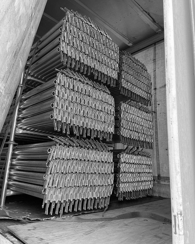 A Black and White Photo of a Stack of Metal Pipes — RM Scaffolding Solutions in Tweed Coast, NSW
