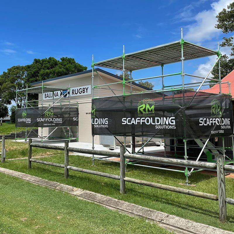 A Fence With Scaffolding in Front of a Building — RM Scaffolding Solutions in Murwillumbah, NSW