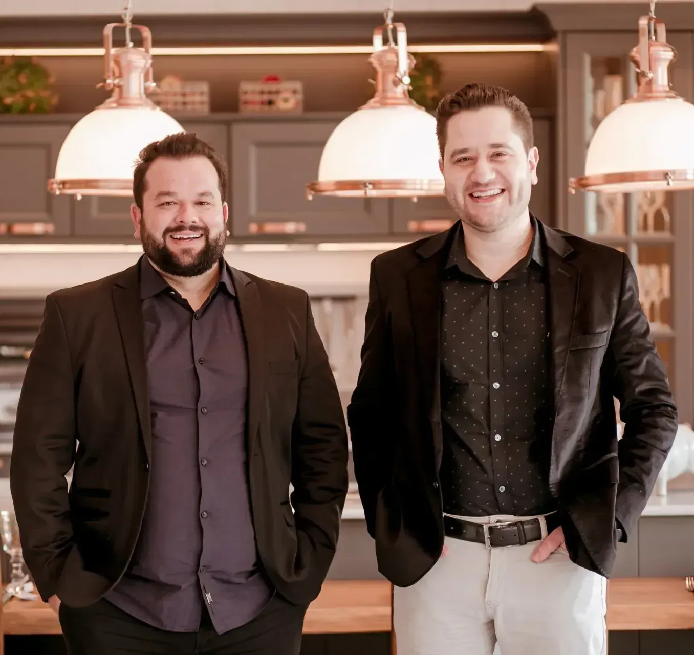 Dois homens de terno estão parados um ao lado do outro em uma cozinha