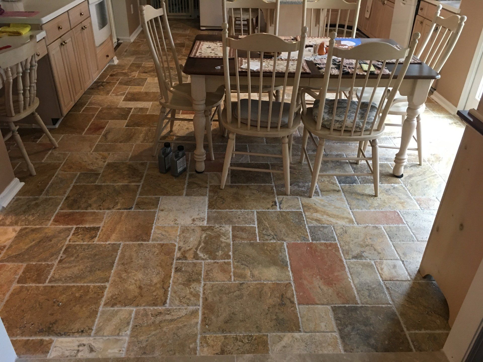 Stone tile kitchen floor with table and chairs.