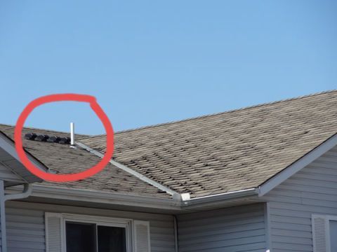 A roof of a house with a blue sky in the background