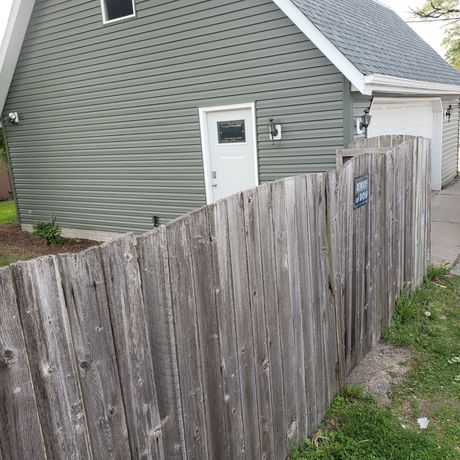 There is a wooden fence in front of a house.