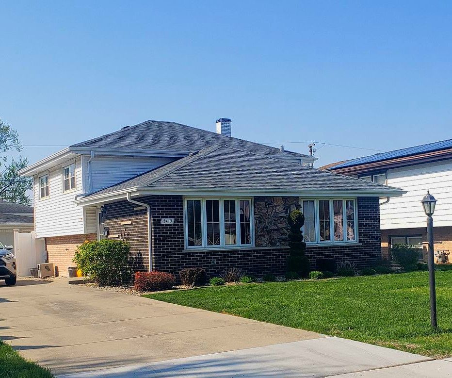 A house with a gray roof and a lot of windows