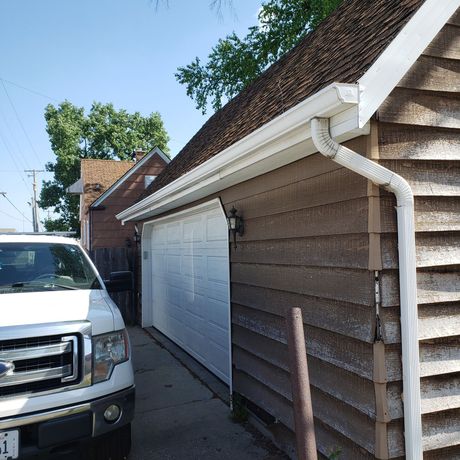 A white truck is parked in front of a garage
