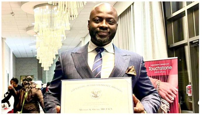 A man in a suit and tie is holding a certificate.