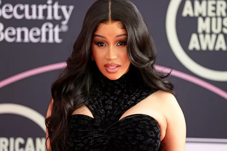 Cardi b is standing on the red carpet at the american music awards.