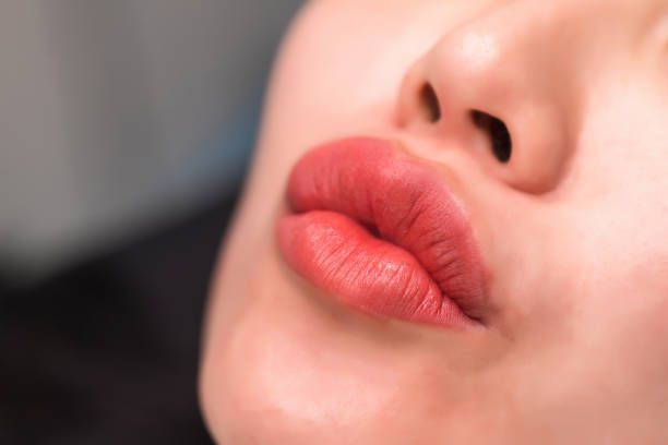 A close up of a woman 's lips with red lipstick.