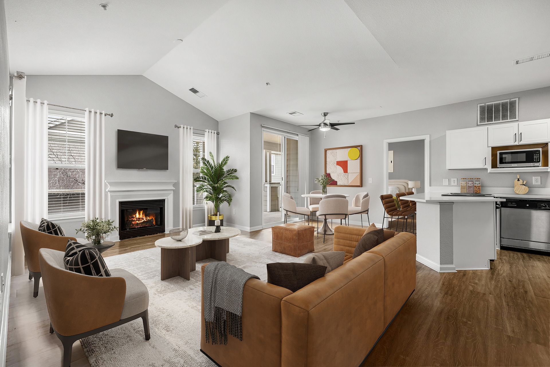 Spacious living room in a modern apartment with fireplace, TV, and seating at Briargate on Main apartments in Parker, CO.