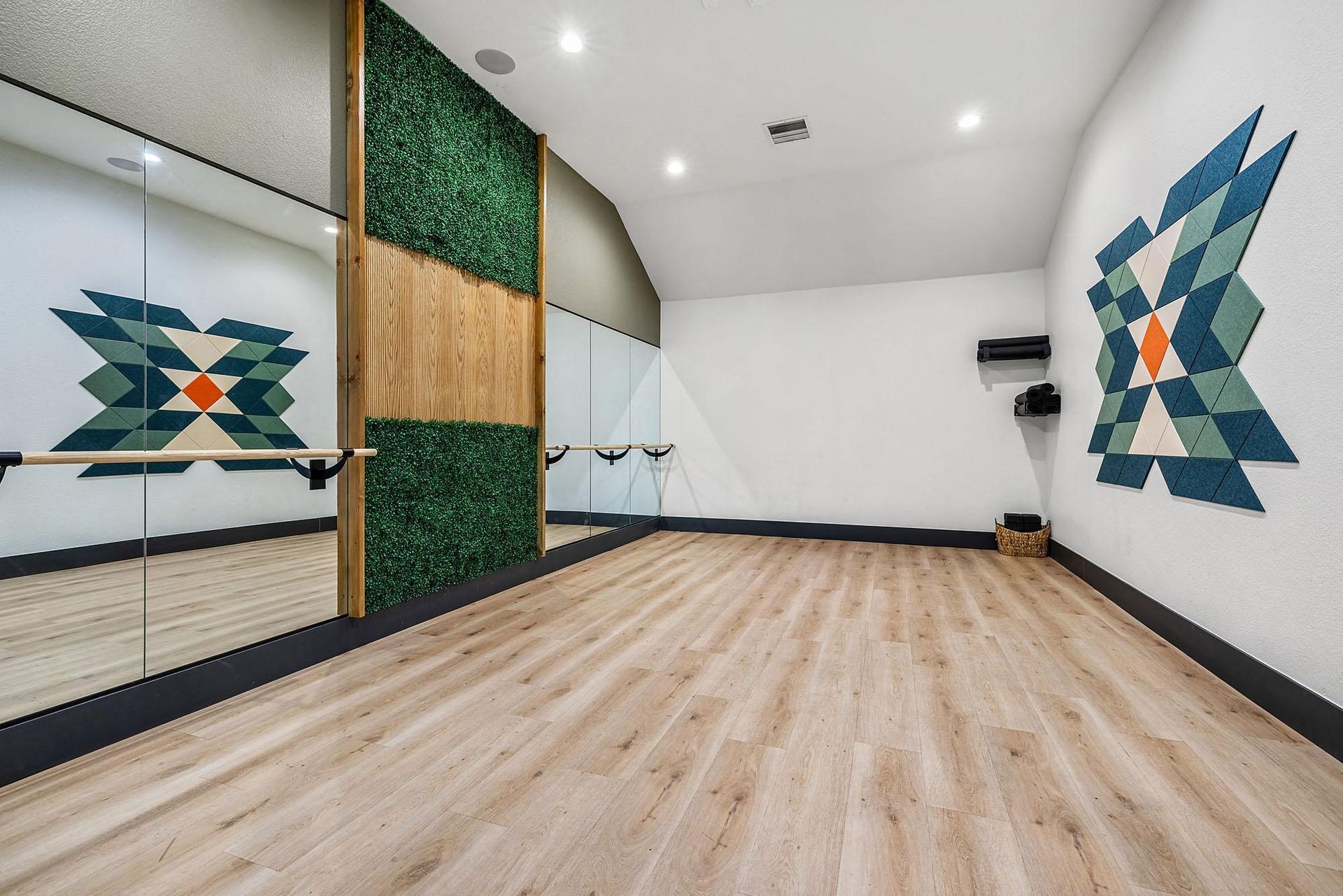 Fitness studio with mirrors along one wall, ballet barre, wood-toned flooring, and geometric wall art at Briargate on Main apartments in Parker, CO.