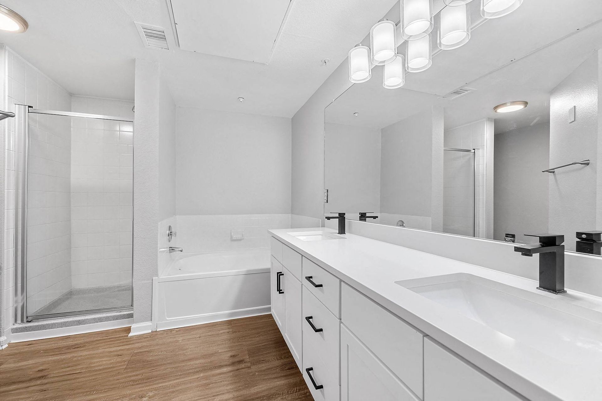 Modern apartment bathroom with double vanity, tub and shower at Briargate on Main apartments in Parker, CO.