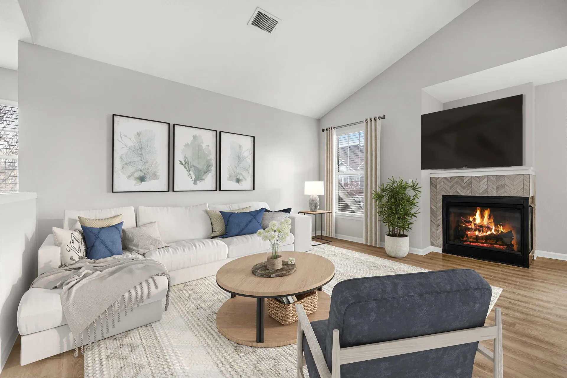 Bright living room with a white sectional sofa, fireplace, and large window at Briargate on Main apartments in Parker, CO.