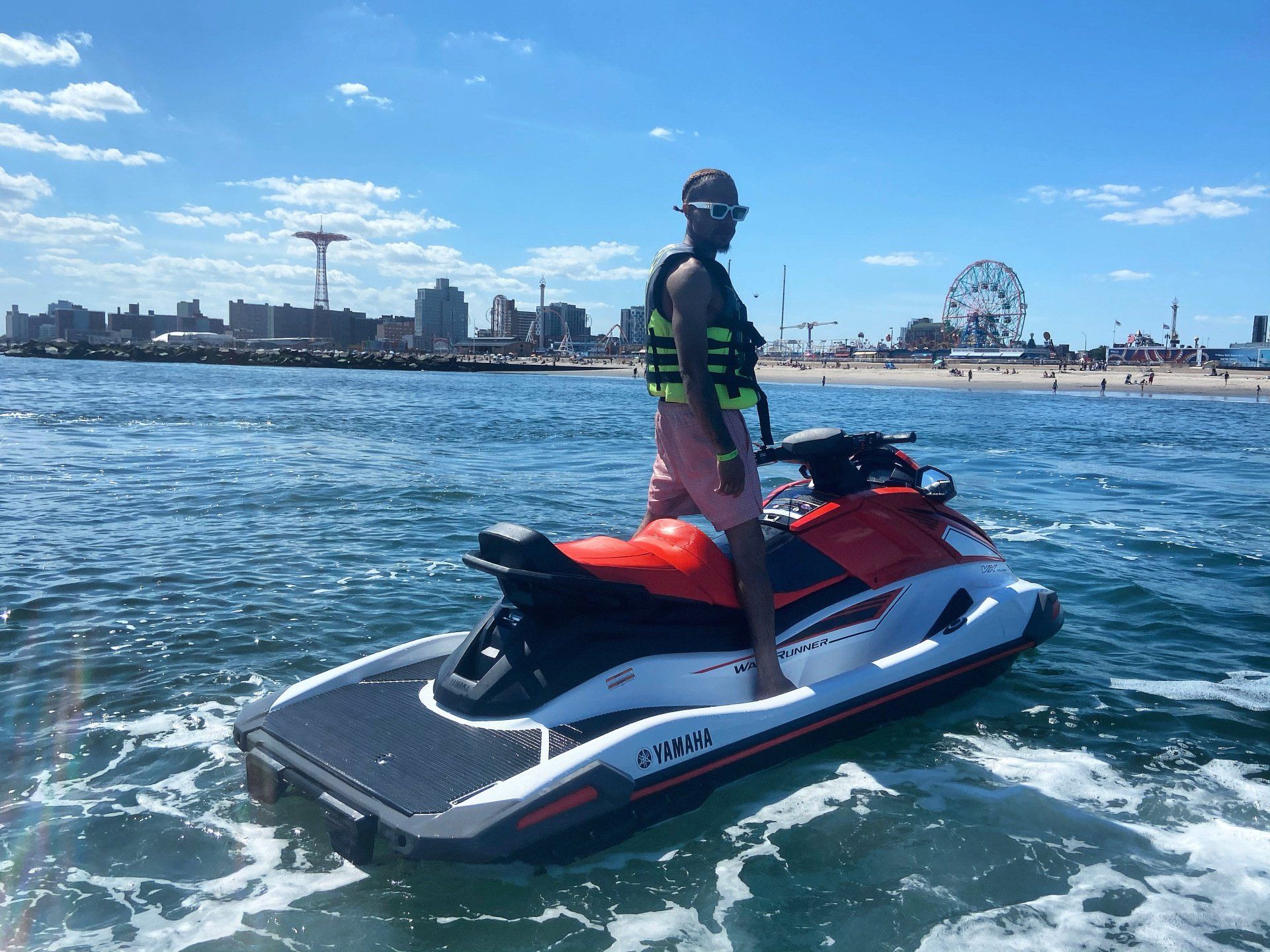 man riding on red jet ski at Coney Island