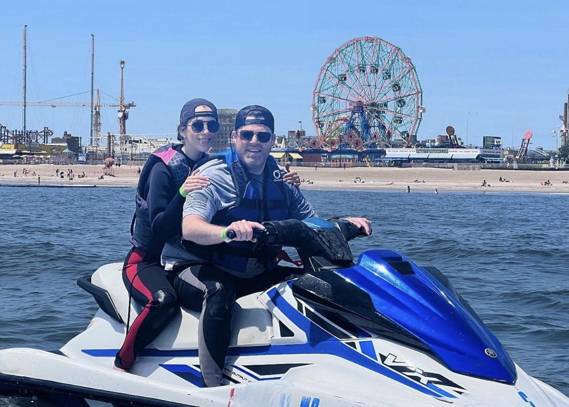 couple sitting on a blue jet ski in new york