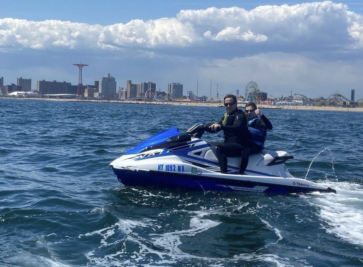 two people riding a blue jet ski in new york